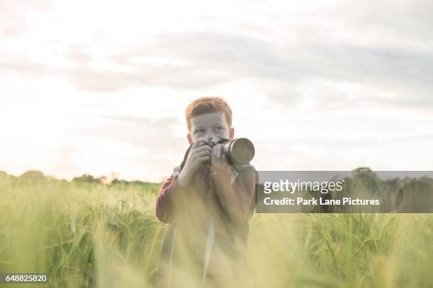 portrait of a 10 yar old boy taking photographs outdoors - 10 11 years stock pictures, royalty-free photos & images