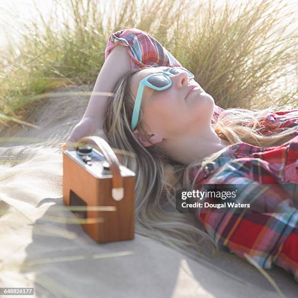 woman listening to radio at beach. - beach music stock pictures, royalty-free photos & images