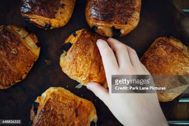 a hand takes a pastry pain au chocolate - pain au chocolat stock pictures, royalty-free photos & images