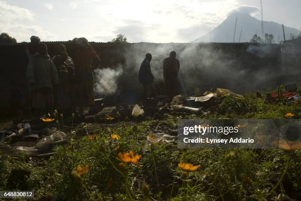 Villagers hide behind walls near a church as Laurent Nkunda's National Congress for the Defence of the People, CNDP, forces fire towards Congolese...