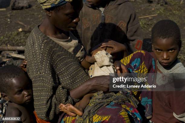 Displaced Congolese woman breast feeds her baby as Laurent Nkunda's National Congress for the Defence of the People, CNDP, forces fire towards...