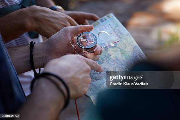 close-up of hands holding compass & map - hiking map stock pictures, royalty-free photos & images