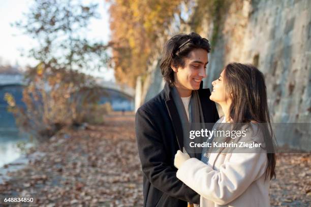 happy young couple at the riverbank of the tiber river, rome, italy - stadt personen rom herbst stock-fotos und bilder