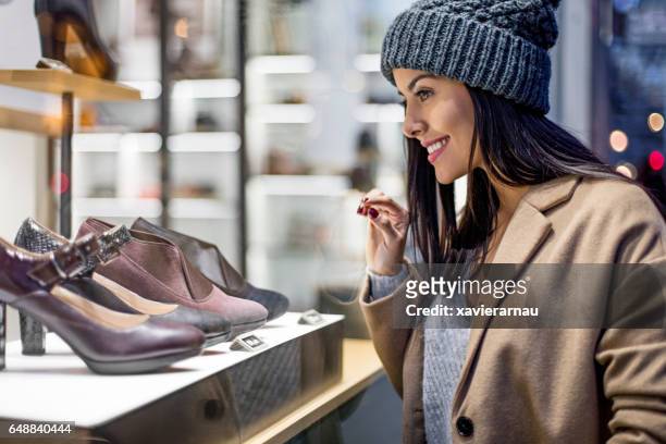 mulher bonita olhando para saltos altos na loja - dress shoe - fotografias e filmes do acervo