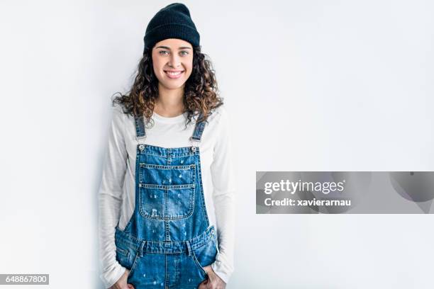 smiling lesbian standing against white wall - white jumpsuit stock pictures, royalty-free photos & images