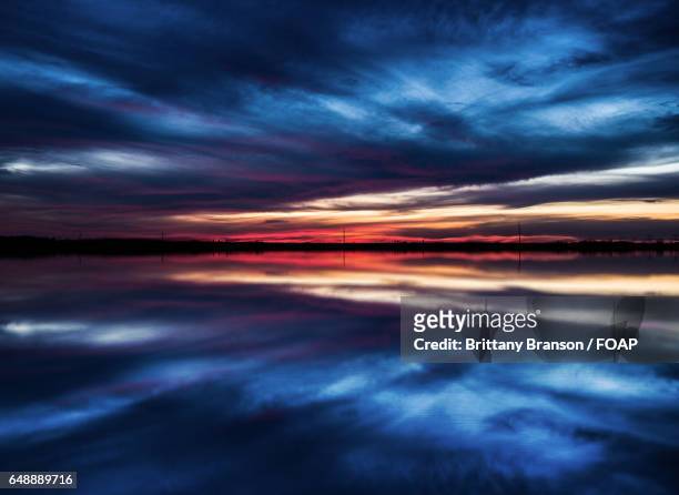 cloudscape reflecting on lake - brittany branson stock-fotos und bilder
