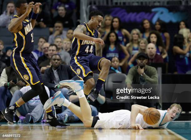 Teammates Thaddeus Young and Jeff Teague of the Indiana Pacers scramble for a loose ball against Cody Zeller of the Charlotte Hornets during their...