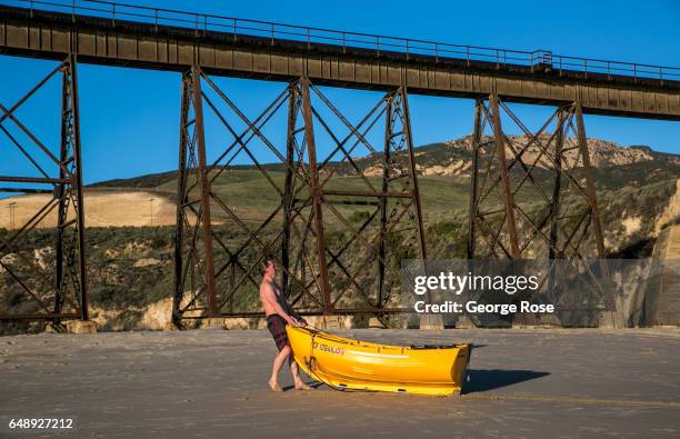 Man drags his small fishing boat onto the sand at Gaviota Beach on December 28 in Gaviota State Park, California. Because of its close proximity to...