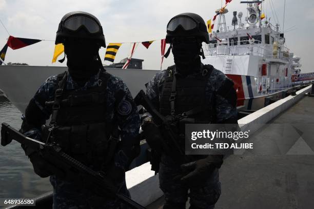 Members of Philippine coast guard anti-terrorism unit stand next to the newly commissioned coast guard's Multi-Role Response Vessel BRP Malapascua...