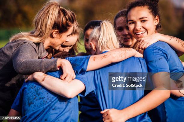 giocatori di rugby femminile insieme in un huddle - sport di squadra foto e immagini stock