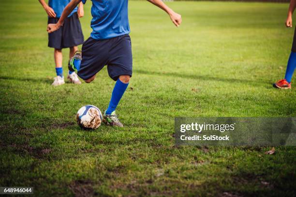 patadas una pelota de fútbol - liga de deportes fotografías e imágenes de stock