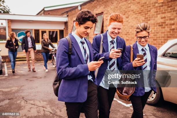 schoolboys on their mobile phones - school students uniform walking stock pictures, royalty-free photos & images