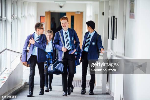teenagers walking to next lesson in school - school uniform stock pictures, royalty-free photos & images