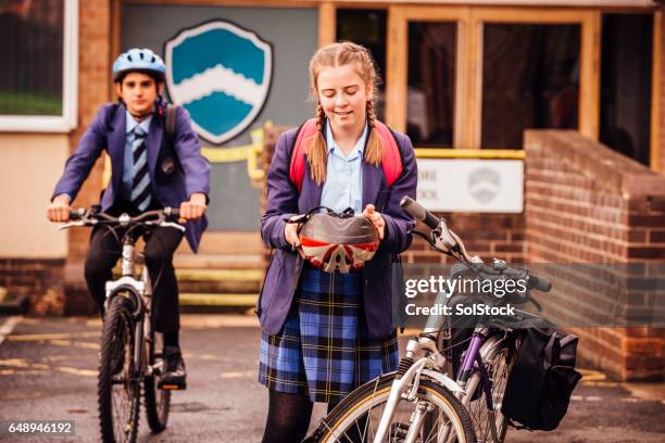 girl preparing to cycle home - schoolgirl stock pictures, royalty-free photos & images