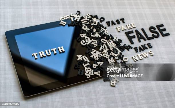 tablet with the wooden words truth, false and fake. - frank wood stock pictures, royalty-free photos & images