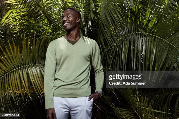 young smilling man in front of a palm tree - v hals stockfoto's en -beelden
