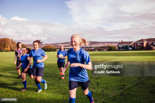 girls running off a soccer playing field - football team running stock pictures, royalty-free photos & images