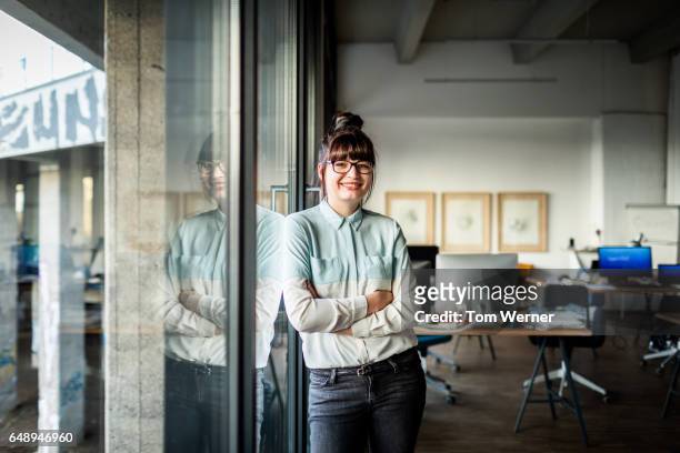 portrait of modern businesswoman in her office - dreiviertelansicht stock-fotos und bilder