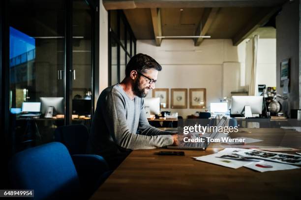 casual businessman working late on a laptop computer - white computer keyboard stock pictures, royalty-free photos & images