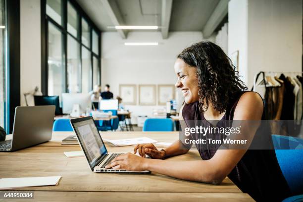 young african businesswoman working on laptop - profile laptop sitting stock-fotos und bilder