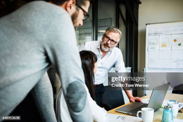 mature businessman speaking in an informal meeting - entrepreneur meeting stock pictures, royalty-free photos & images