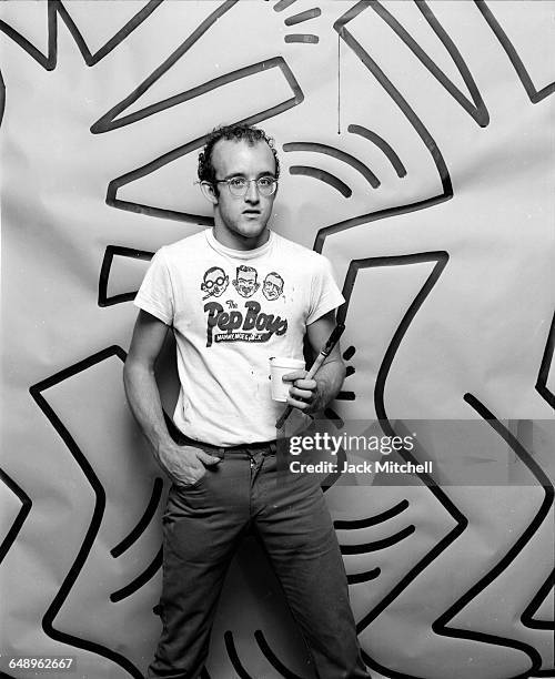 Graffiti and visual artist Keith Haring photographed with one of his paintings in April 1984. Photo by Jack Mitchell/Getty Images.