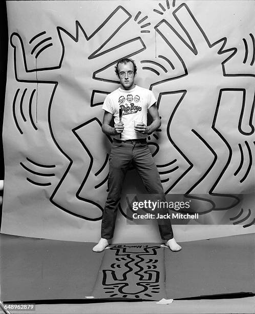 Graffiti and visual artist Keith Haring photographed with one of his paintings in April 1984. Photo by Jack Mitchell/Getty Images.