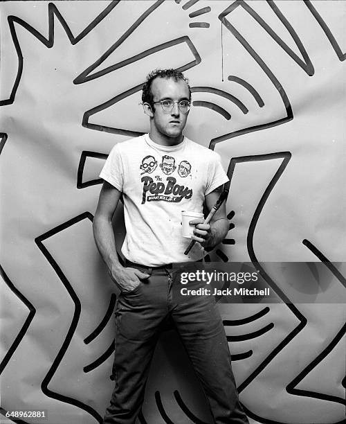 Graffiti and visual artist Keith Haring photographed with one of his paintings in April 1984. Photo by Jack Mitchell/Getty Images.