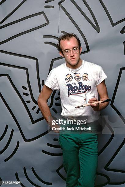 Graffiti and visual artist Keith Haring photographed with one of his paintings in April 1984. Photo by Jack Mitchell/Getty Images.