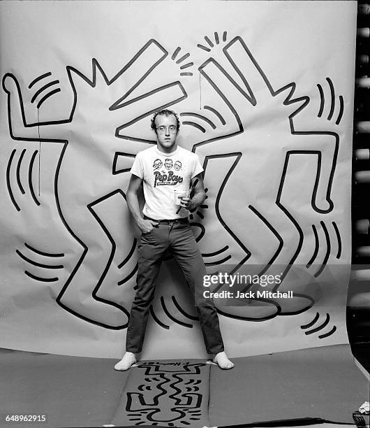 Graffiti and visual artist Keith Haring photographed with one of his paintings in April 1984. Photo by Jack Mitchell/Getty Images.