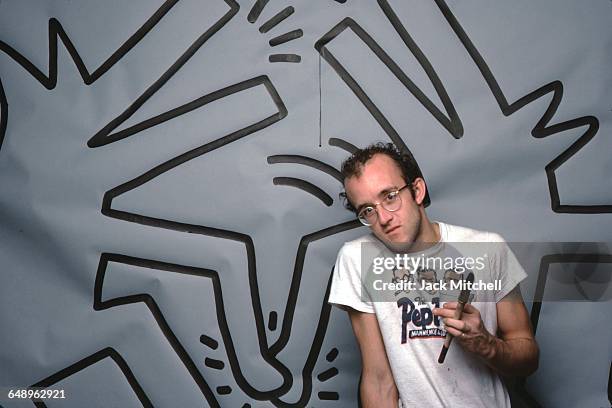 Graffiti and visual artist Keith Haring photographed with one of his paintings in April 1984. Photo by Jack Mitchell/Getty Images.