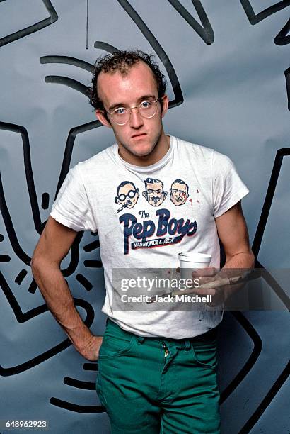 Graffiti and visual artist Keith Haring photographed with one of his paintings in April 1984. Photo by Jack Mitchell/Getty Images.