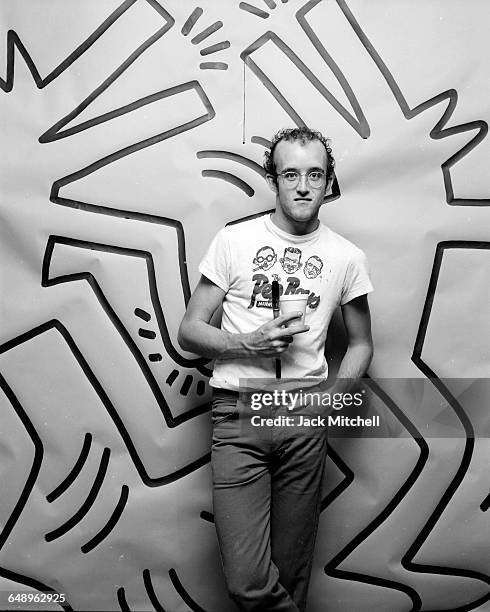 Graffiti and visual artist Keith Haring photographed with one of his paintings in April 1984. Photo by Jack Mitchell/Getty Images.