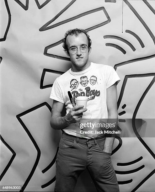 Graffiti and visual artist Keith Haring photographed with one of his paintings in April 1984. Photo by Jack Mitchell/Getty Images.