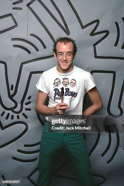 Graffiti and visual artist Keith Haring photographed with one of his paintings in April 1984. Photo by Jack Mitchell/Getty Images.