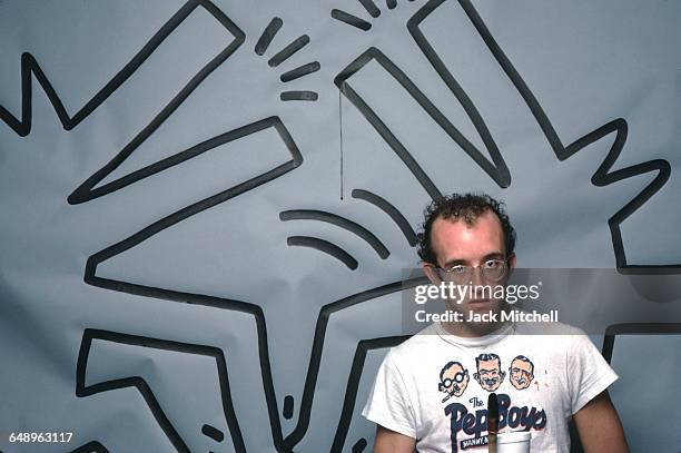 Graffiti and visual artist Keith Haring photographed with one of his paintings in April 1984. Photo by Jack Mitchell/Getty Images.