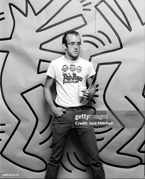 Graffiti and visual artist Keith Haring photographed with one of his paintings in April 1984. Photo by Jack Mitchell/Getty Images.