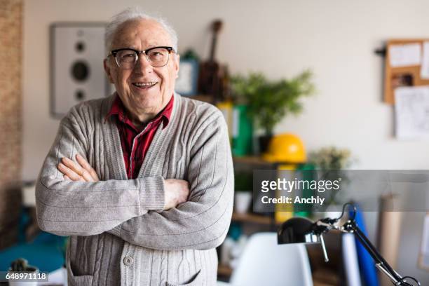 actieve senior glimlachend met gekruiste armen - at home portrait stockfoto's en -beelden