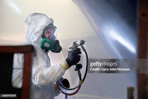boat building craftsman paint spraying - spray paint stock pictures, royalty-free photos & images