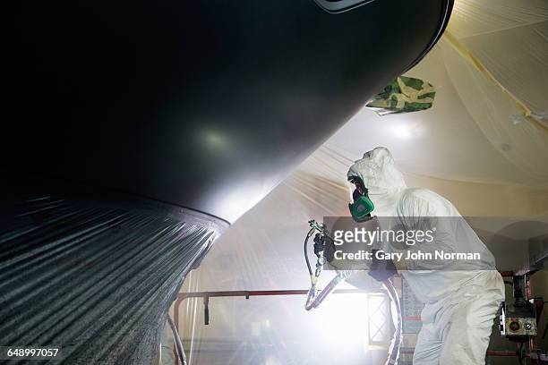 boat building craftsman spraying paint - shipyard stock-fotos und bilder