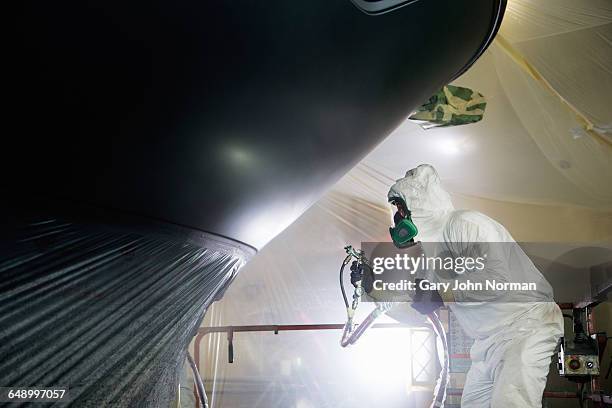 boat building craftsman spraying paint - shipyard stock pictures, royalty-free photos & images