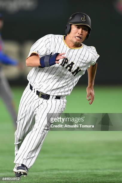 Norichika Aoki of Japan runs to the home as Yoshitomo Tsutsugo of Japan hits a RBI single in the first inning of the World Baseball Classic Pool B...