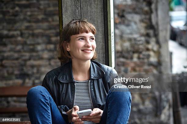 smiling young woman with cell phone - fossetta foto e immagini stock