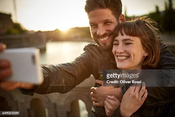 happy young couple taking selfie by the riverside - dating stock-fotos und bilder