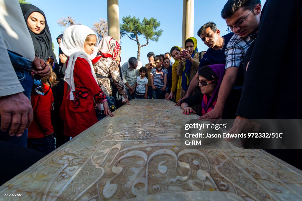 Tourists offer prayers and thanks at the Tombstone of Hafez Shirazi a famous poet.