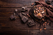 Cocoa beans and chocolate on wooden background