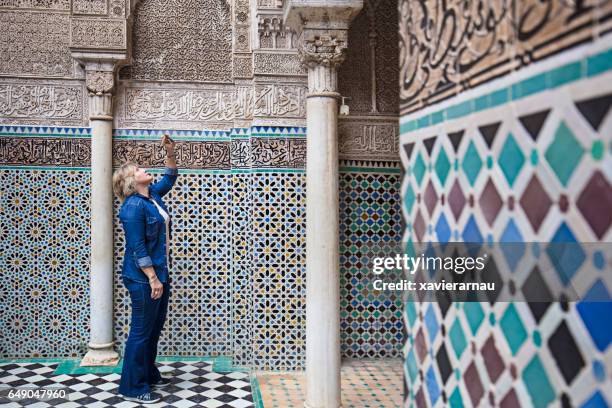 reife frau zu besuch attarine madrasa in fez - fes marokko stock-fotos und bilder