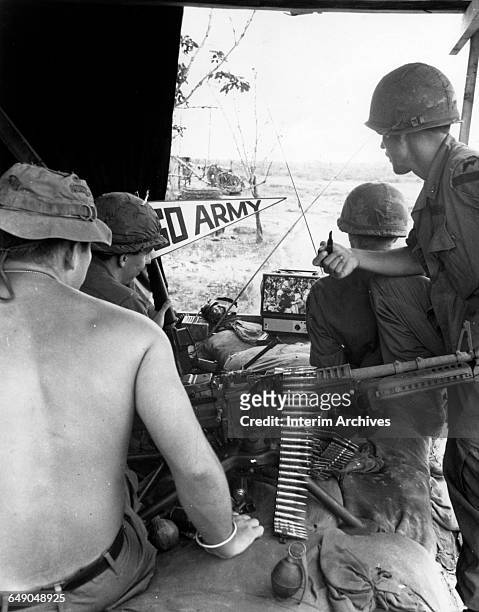 Soldiers from the 1st Air Cavalry gather around a television to take in an Army football game at Basecamp Phuoc Vinh as televised by American Forces...