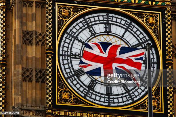 British Union flag, also known as the Union Jack, flies beside a clock face on Elizabeth Tower, also known as 'Big Ben', in London, U.K., on...