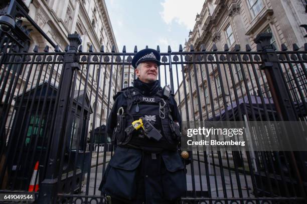 British police officer, armed with a taser gun, stands on patrol at the gates to Downing Street in London, U.K., on Thursday, March 2, 2017. U.K....